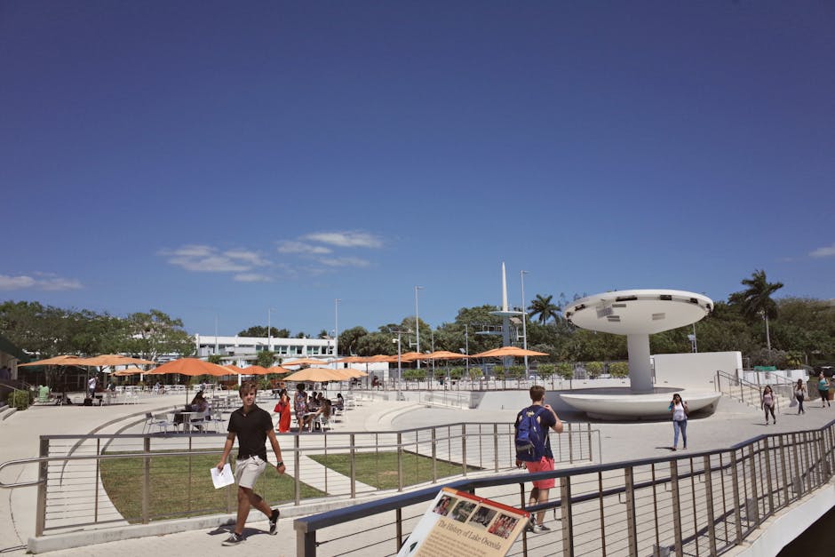 Outdoor campus area at a university in Coral Gables, FL, with students and modern architecture.
